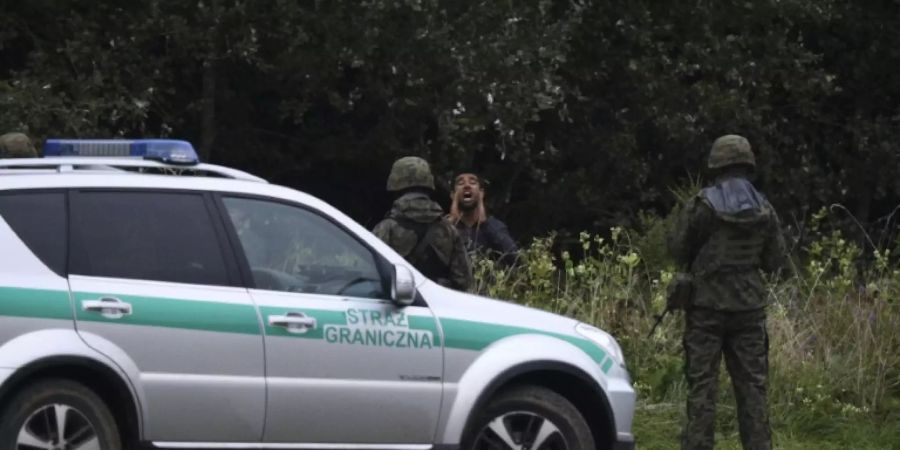 Polnische Polizei und Flüchtlng an Grenze zu Belarus