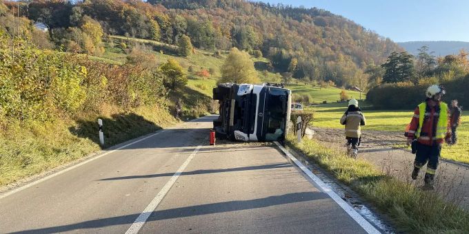 Lastwagen kommt von der Strasse ab und kippt auf die Seite.