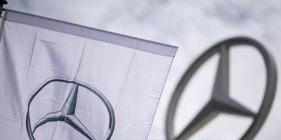 Eine Fahne mit dem Logo der Marke Mercedes-Benz, dem Mercedes-Stern, weht vor einem Showroom der Firma. Foto: Sebastian Gollnow/dpa