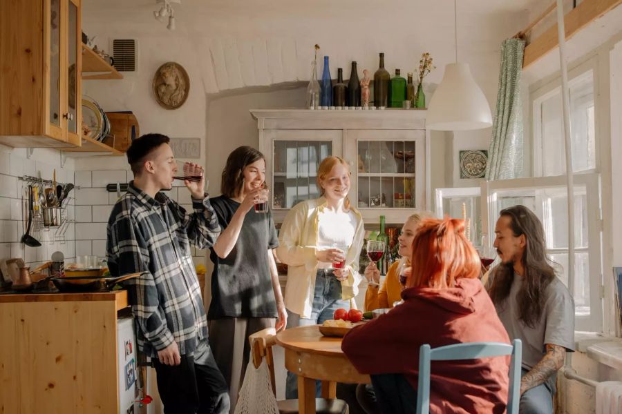 Junge Studenten sitzen am Küchentisch.