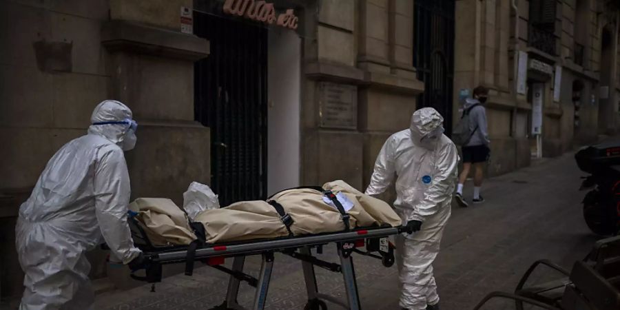 dpatopbilder - Leichenbestatter transportieren den Leichnam eines älteren Menschen, der in einem Pflegeheim an Covid-19 gestorben ist. Foto: Emilio Morenatti/AP/dpa