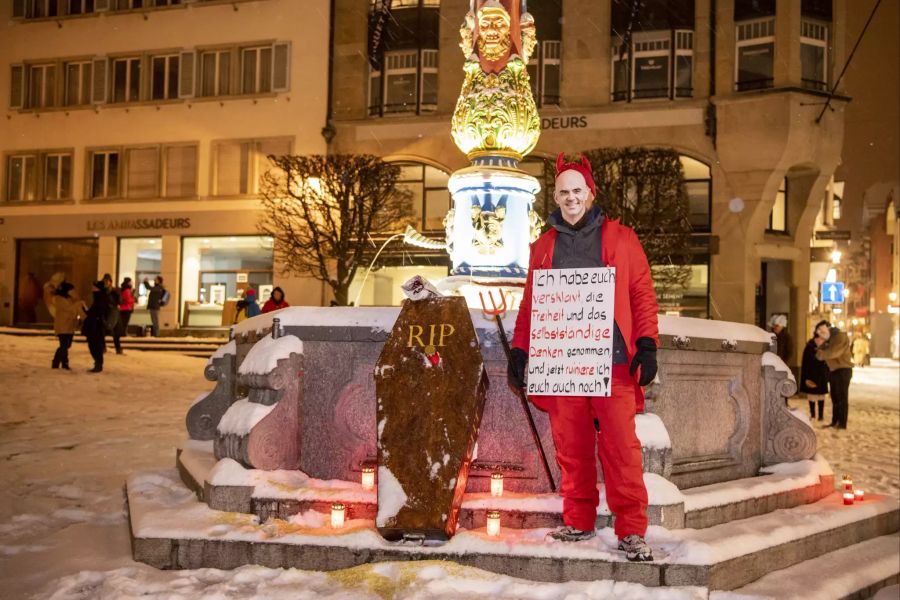 Ein Fasnächtler als Alain Berset verkleidet, posiert beim Grabstein am Fritschibrunnen auf dem Kapellplatz in der Altstadt von Luzern.