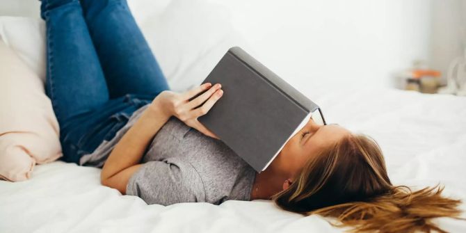 Frau mit Buch auf Bett