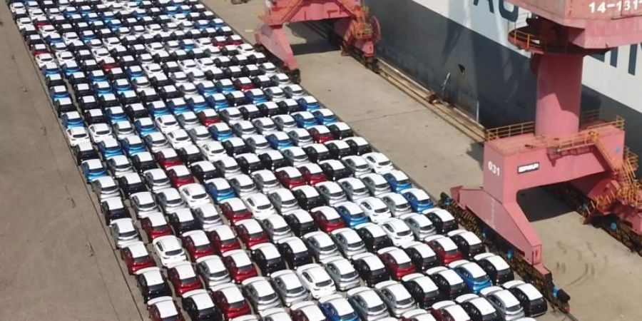 Autos stehen neben den Transportschiffen im Hafen von Lianyungang in Shanghai. Foto: Geng Yuhe/XinHua/dpa