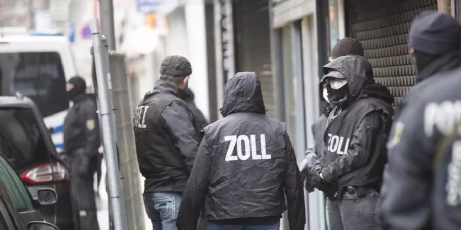 Polizisten und Zollbeamte während des Einsatzes auf der Kölner Keupstrasse. Mehr als 600 Beamte haben in mehreren Bundesländern einen Schlag gegen eine mutmassliche Bande von Geldwäschern geführt. Foto: Thomas Banneyer/dpa