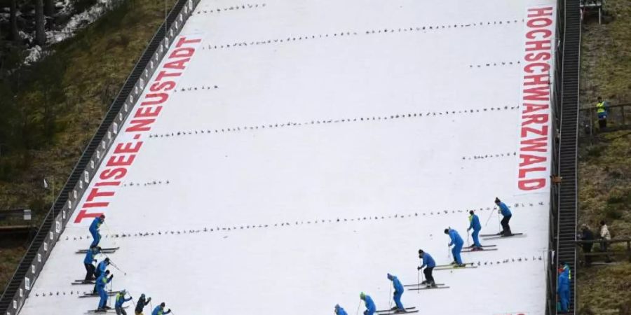 Helfer präparieren die Hochfirstschanze in Titisee-Neustadt. Foto: Patrick Seeger/dpa