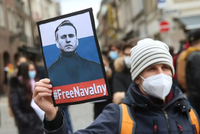 Nordrhein-Westfalen, Düsseldorf: Ein Demonstrant hält vor dem Rathaus ein Plakat mit dem Bild des russischen Oppositionsführers Nawalny mit der Aufschrift "#FreeNavalny" in der Hand. Nawalny