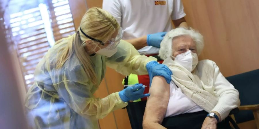Eine Ärztin impft eine Seniorin gegen Corona