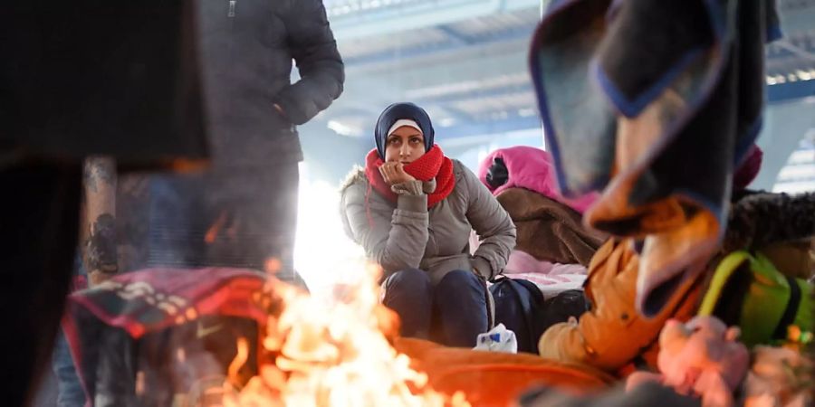ARCHIV - Wärmen am Lagerfeuer in einer leeren Markthalle nahe der türkisch-griechischen Grenze: In der Türkei leben derzeit rund 4 Millionen Flüchtlinge. Foto: Mohssen Assanimoghaddam/dpa