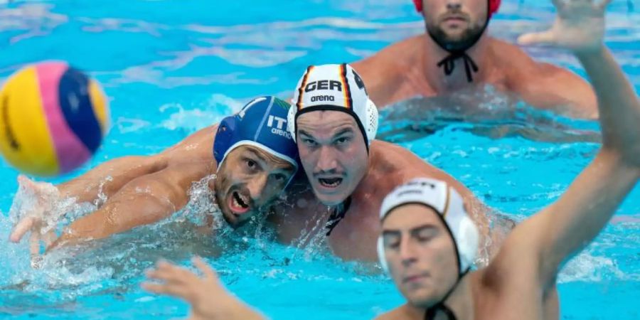 Julian Real (M) und Matteo Aicardi (l) von Italien versuchen, an den Ball zu kommen. Hinten Deutschlands Torhüter Moritz Schenkel. Foto: Bernd Thissen