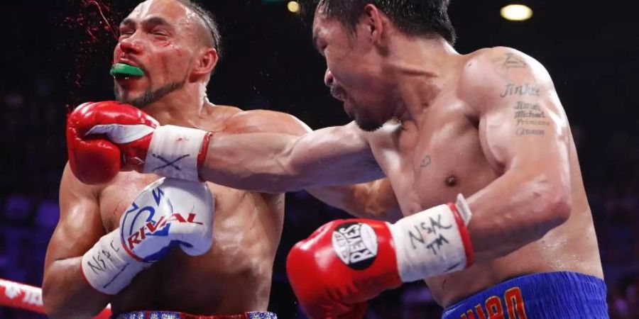 Kampf im Weltergewicht: Keith Thurman (l) wird hart am Kopf von Manny Pacquiao getroffen. Foto: John Locher/AP
