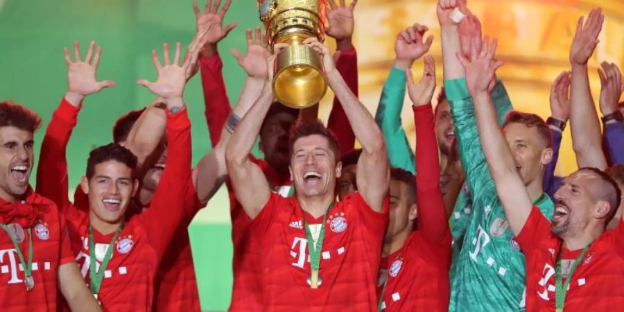 Bayerns Doppel-Torschütze Robert Lewandowski (M.) stemmt den DFB-Pokal in den Berliner Nachthimmel. Foto: Jan Woitas