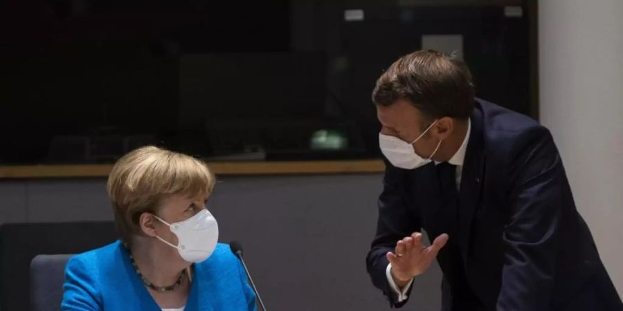 Bundeskanzlerin Angela Merkel spricht mit dem französischen Präsidenten Emmanuel Macron am zweiten Tag des EU-Gipfels. Foto: Francisco Seco/AP Pool/dpa