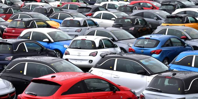 Autos stehen vor dem Autofabrik auf einem Parkplatz. Die Autobranche steht unter Druck. Autohandel unter Druck
