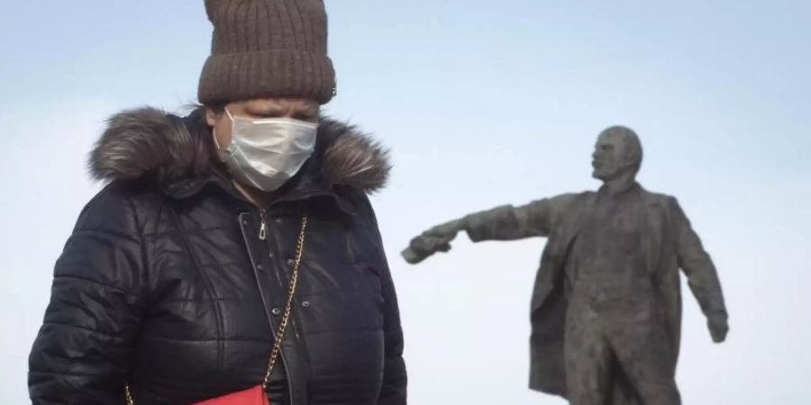 «Diese Infektion kennt keine Grenzen»: Eine Frau unterwegs mit Gesichtsmaske in St. Petersburg. Foto: Dmitri Lovetsky/AP/dpa