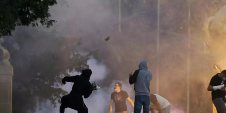 Demonstranten stossen bei Protesten in Belgrad mit Polizisten zusammen. Foto: Darko Vojinovic/AP/dpa