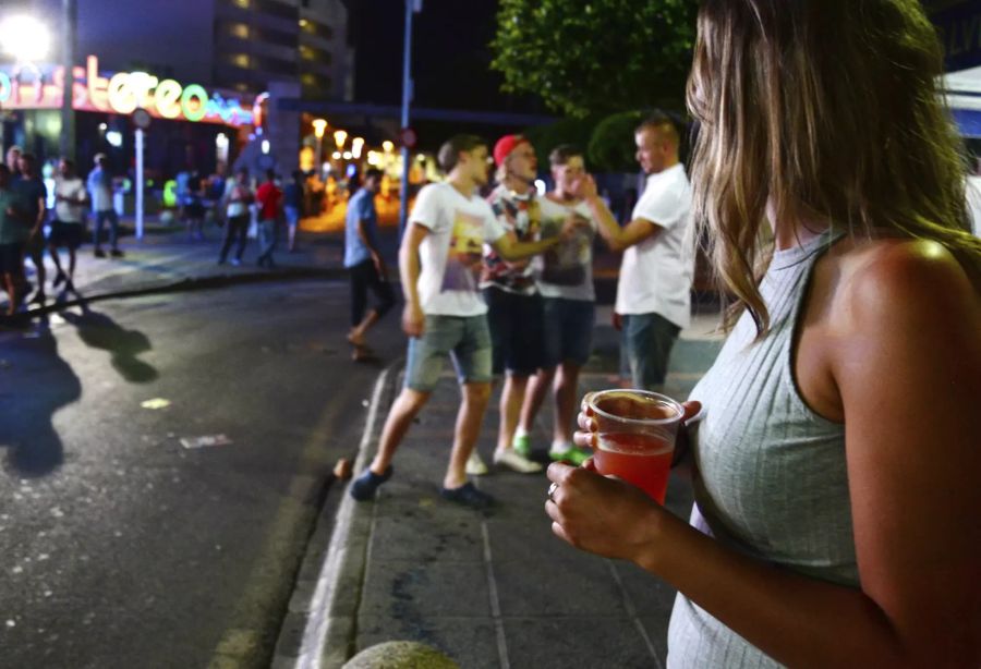 Eine Touristin in Magaluf trinkt Alkohol.