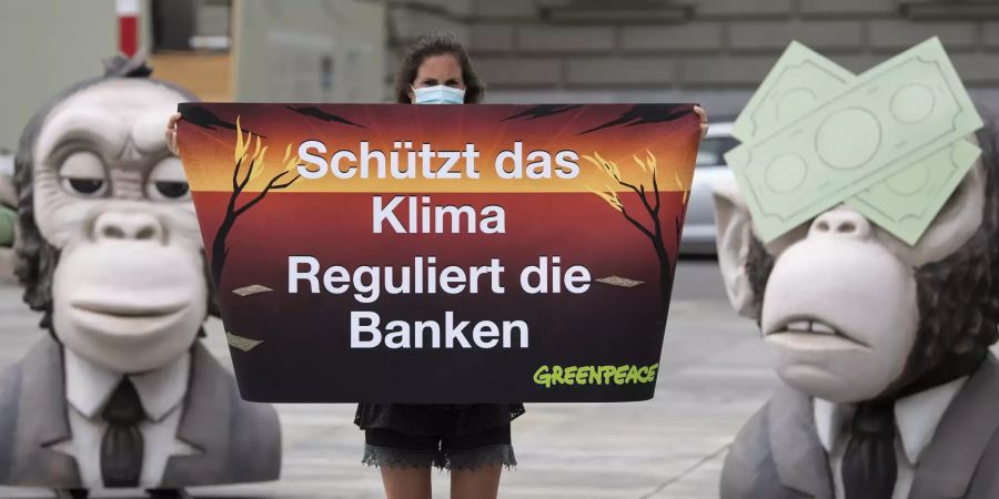 Aktivisten von Greenpeace Schweiz demonstrieren schon 2020 mit übergrossen Affenköpfen gegen die Finanzindustrie in Bern. Greenpeace macht diese wegen der Finanzierung von Brennstoffen wie Kohle oder Öl aus Fracking für die Klimakrise verantwortlich.