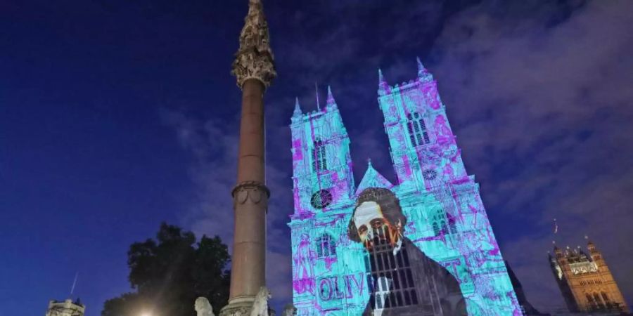 Charles Dickens wird auf die Westtürme der Westminster Abbey projiziert. Foto: Yui Mok/PA Wire/dpa