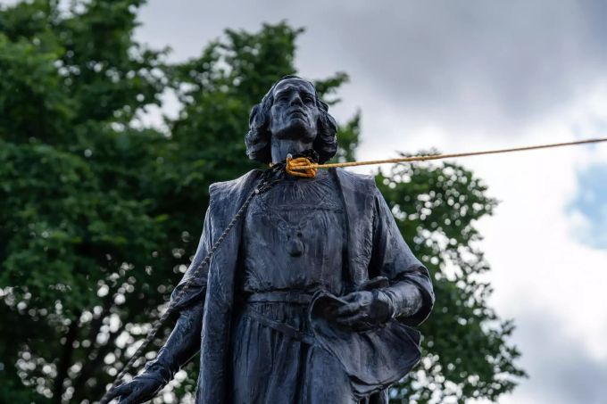 Zwei Seile werden um den Hals einer Christopher-Kolumbus-Statue gebunden, bevor diese von einer Gruppe umgerissen wird. (Archivbild) Kolumbus
