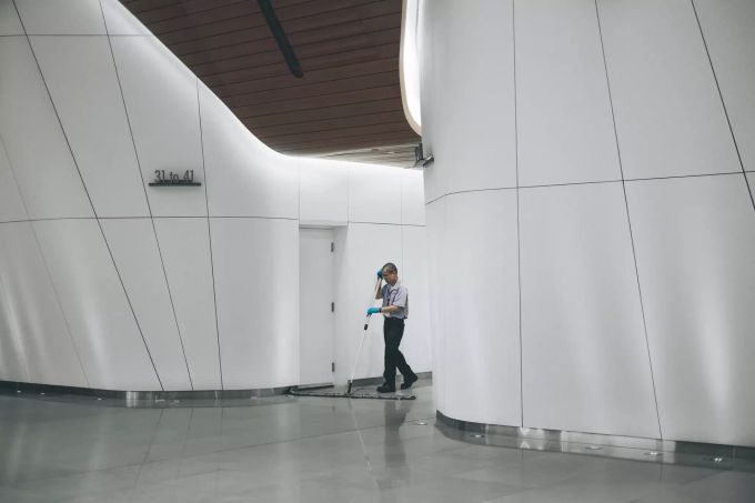 Ein Hauswart an der Arbeit. Hauswart Reinigung weiss Gebäude