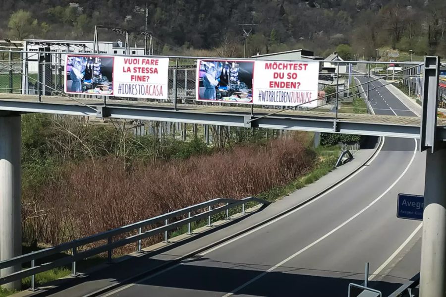 Eine Fussgängerüberführung und Warnplakate, die auf die Folgen einer schweren Coronavirus-Erkrankung hinweisen, führen über eine leere Landstrasse bei Avegno am Karfreitag. Die Warnungen scheinen geholfen zu haben, Herr und Frau Schweizer hielten sich bisher mehrheitlich an die BAG-Regelungen.