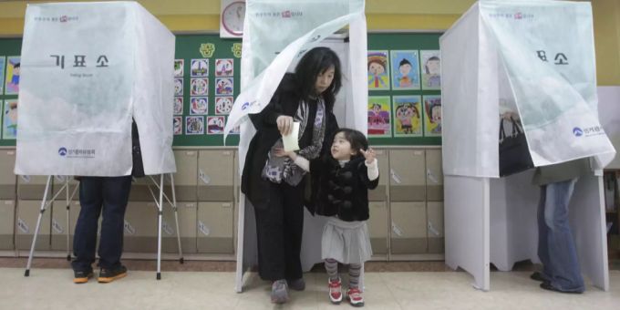 Eine Mutter verlässt die Abstimmungskabine Wahlen Südkorea