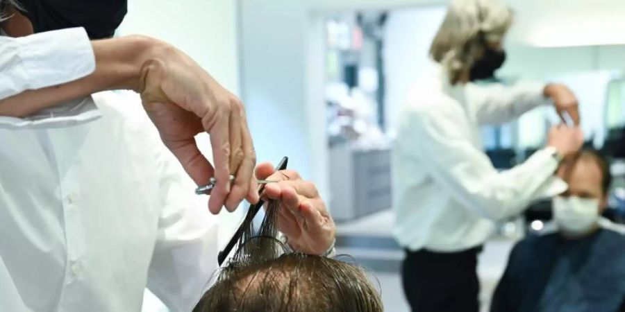 Ein höherer Mindestlohn und Ausgaben für Hygienemassnahmen haben zu höheren Friseurpreisen geführt. Foto: Arne Dedert/dpa/Archiv