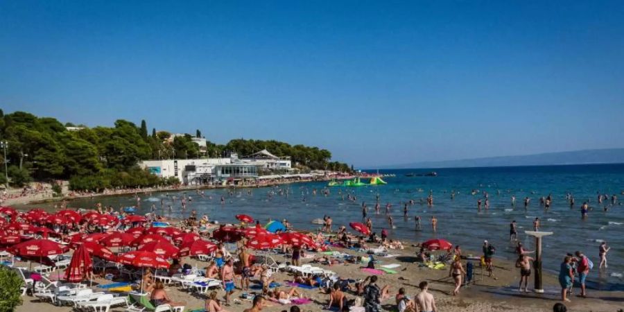 Badegäste sonnen sich am Strand Bacvice. Wegen der gestiegenen Zahl von Corona-Neuinfektionen hat das Auswärtige Amt eine Reisewarnung für Teile des Urlaubslands Kroatien ausgesprochen. Foto