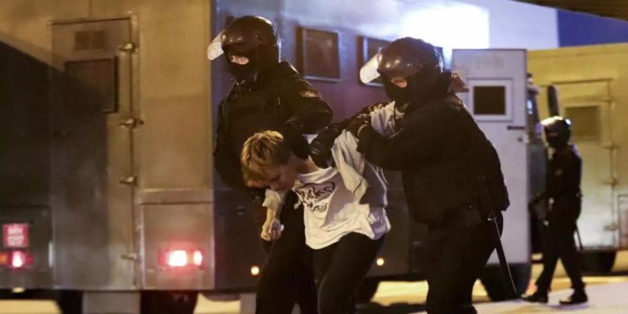 Polizisten halten einen verhafteten Demonstranten in Minsk fest. Foto: Uncredited/AP/dpa