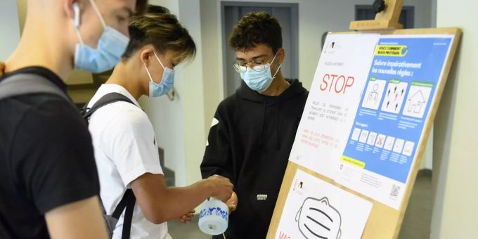 Schweizer Schüler desinfizieren sich wegen des Coronavirus die Hände mit Desinfektionsmittel. schnupfen