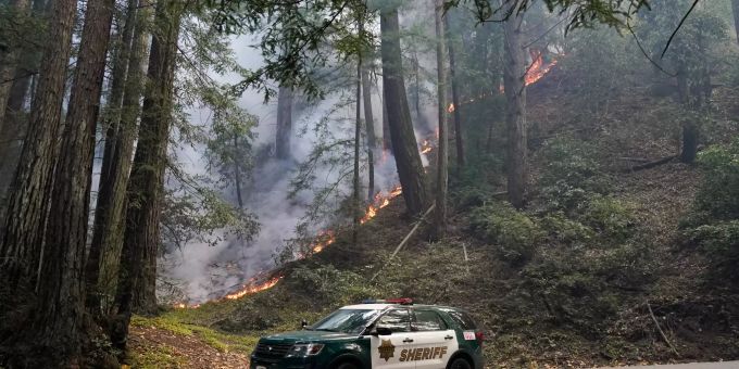 Ein Polizeifahrzeug steht an einer Strasse neben einem Waldbrand in Kalifornien. Waldbrände in Kalifornien