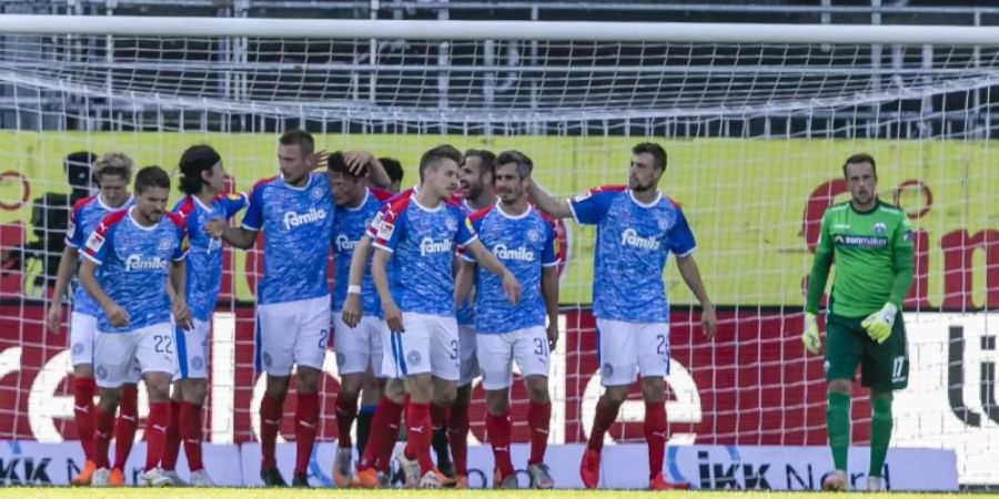 Die Spieler von Holstein Kiel jubeln nach dem Tor zum 1:0 durch Alexander Mühling. Foto: Frank Molter/dpa