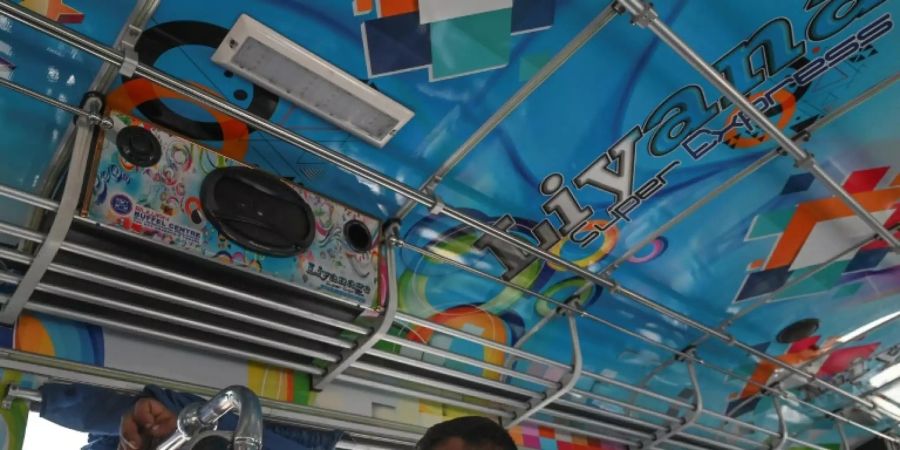 Fahrgäste unter einem Bus-Lautsprecher