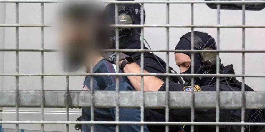 Vermummte Beamte einer Spezialeinheit der Polizei bringen den terrorverdächtigen Mann zur Haftvorführung am Gericht. Foto: Boris Roessler/dpa