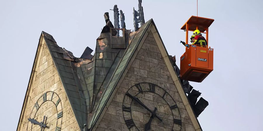 Feuerwehrleute schauen sich die abgebrannte Spitze des Kirchturms der reformierten Kirche von Herzogenbuchsee aus einem Kran an. Das Feuer im Turm der reformierten Kirche hatte an Heiligabend grossen Schaden angerichtet. Ein Teil der Holzkonstruktion stürzte ein und riss ein Loch ins Kirchenschiff.