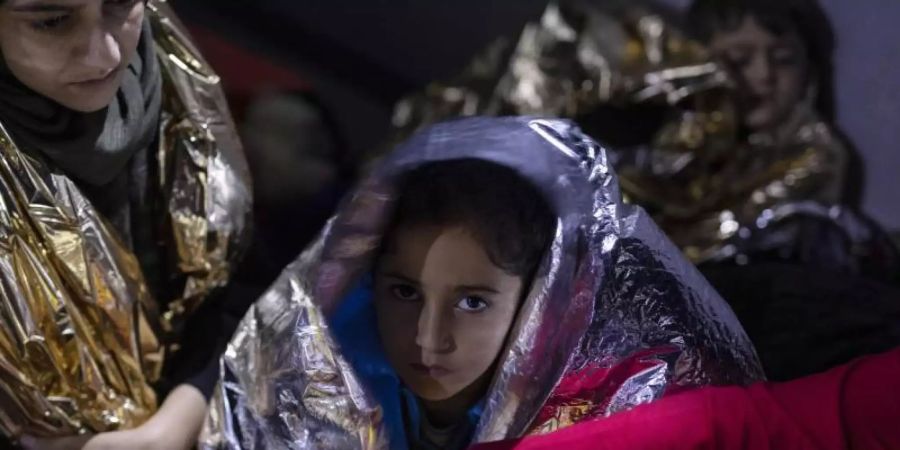 Ein irakisches Mädchen und anderen Flüchtlinge sind in Thermodecken gehüllt. 23 Migranten und Flüchtlinge aus Syrien, Irak, Palästina und dem Iran, die versuchten, mit einem Boot die Ägäis von der Türkei zur griechischen Insel Samos zu überqueren, wurden von der griechischen Küstenwache gerettet. Foto: Petros Giannakouris