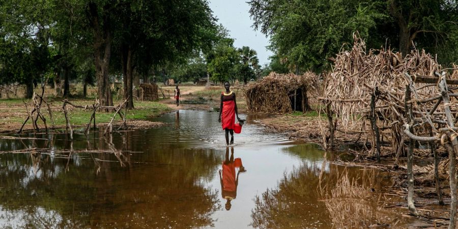 Eine Frau watet durch das Hochwasser zwischen verlassenen Unterkünften im Dorf Majak Awar im Südsudan. Dort sind ganze Bundesstaaten überflutet. Sieben der zehn Klimakrisenherde, die die Nichtregierungsorganisation Oxfam in einer aktuellen Studie identifiziert hat, liegen in Afrika.