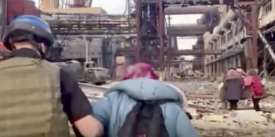 Ein ukrainischer Kämpfer hilft einer Frau bei der Flucht aus dem Stahlwerk Azovstal in Mariupol. (Archivbild)