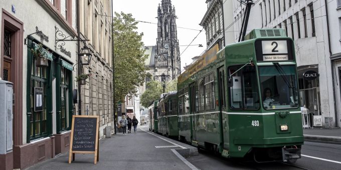 Basel will die Nutzung des öffentlichen Verkehrs fördern. Tram Basel Strasse Sommer