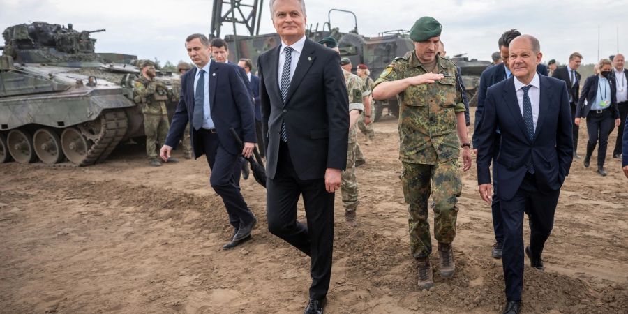 Litauens Staatspräsident Gitanas Nauseda (M) besucht mit Bundeskanzler Olaf Scholz das Camp Adrian Rohn im litauischen Pabrade, wo mehr als 1000 Bundeswehr-Soldaten stationiert sind.