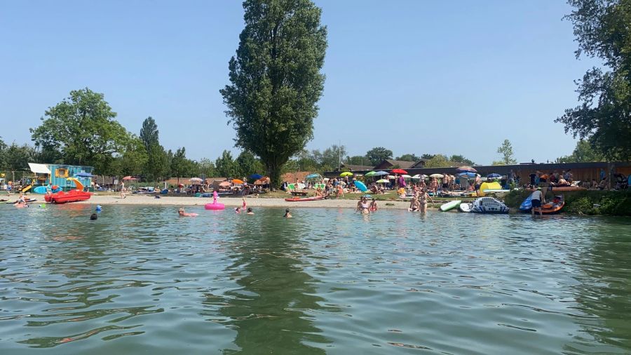 Auch am Bielersee bei Erlach BE kühlen sich zahlreiche Menschen im Wasser ab.