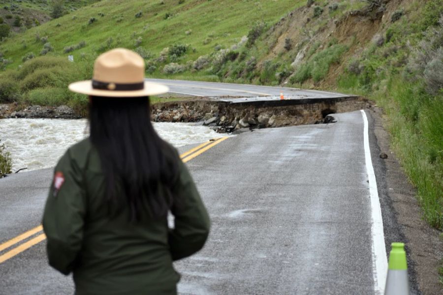 Ein Ranger des Yellowstone-Nationalparks steht am 19. Juni 2022 in der Nähe von Gardiner, Montana, an einer Strasse, die durch die Überschwemmungen am Gardner River in der Vorwoche zerstört