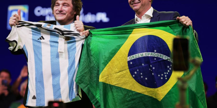 Der brasilianische Senator Flavio Bolsonaro (r) hält eine Nationalflagge, während der argentinische Präsident Javier Milei ein argentinisches Trikot in der Hand hält - dies geschah ...