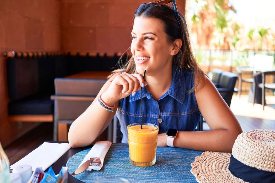 Glückliche Frau im Restaurant mit Getränk