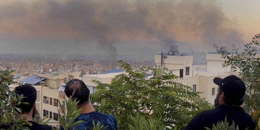 Libanesische Bürger beobachten die Rauchentwicklung nach israelischen Luftangriffen in den südlichen Vororten von Beirut, Libanon, Samstag, 28. September 2024.