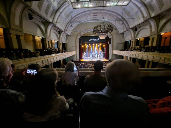Konzertsaal mit filmenden Menschen