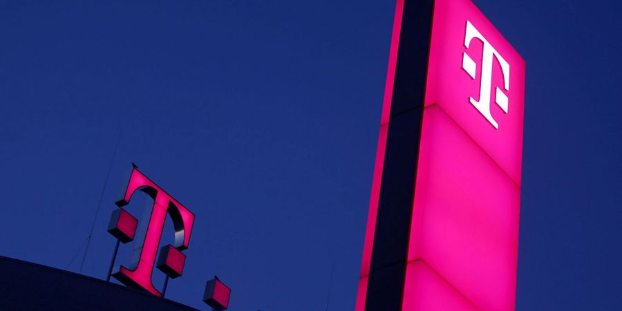 Das Logo der Deutschen Telekom leuchtet auf dem Dach der Unternehmenszentrale.