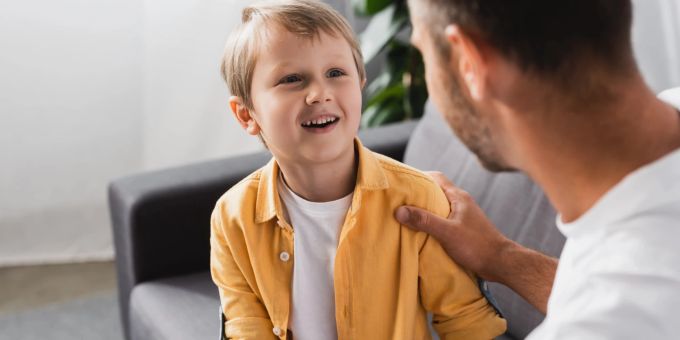 Eine neue Elternfigur im Leben zu haben, ist vor allem für jüngere Kinder eine grosse Umstellung. Lächelnder Junge mit Vater