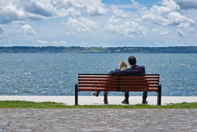 Stille Momente sind zum Geniessen da, vor allem in Liebesbeziehungen. Paar am Wasser auf einer Bank
